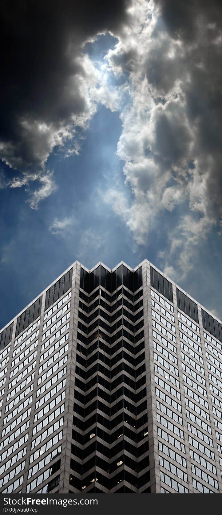 Office building with dramatic cloudy skies and lighting. Office building with dramatic cloudy skies and lighting.