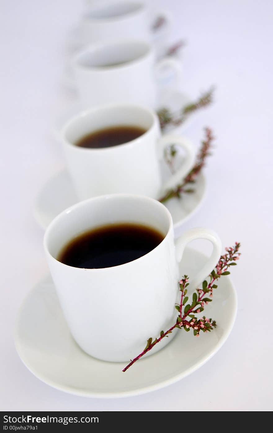 Black coffee in white cups, decorated with  pink flowers, white background. Black coffee in white cups, decorated with  pink flowers, white background