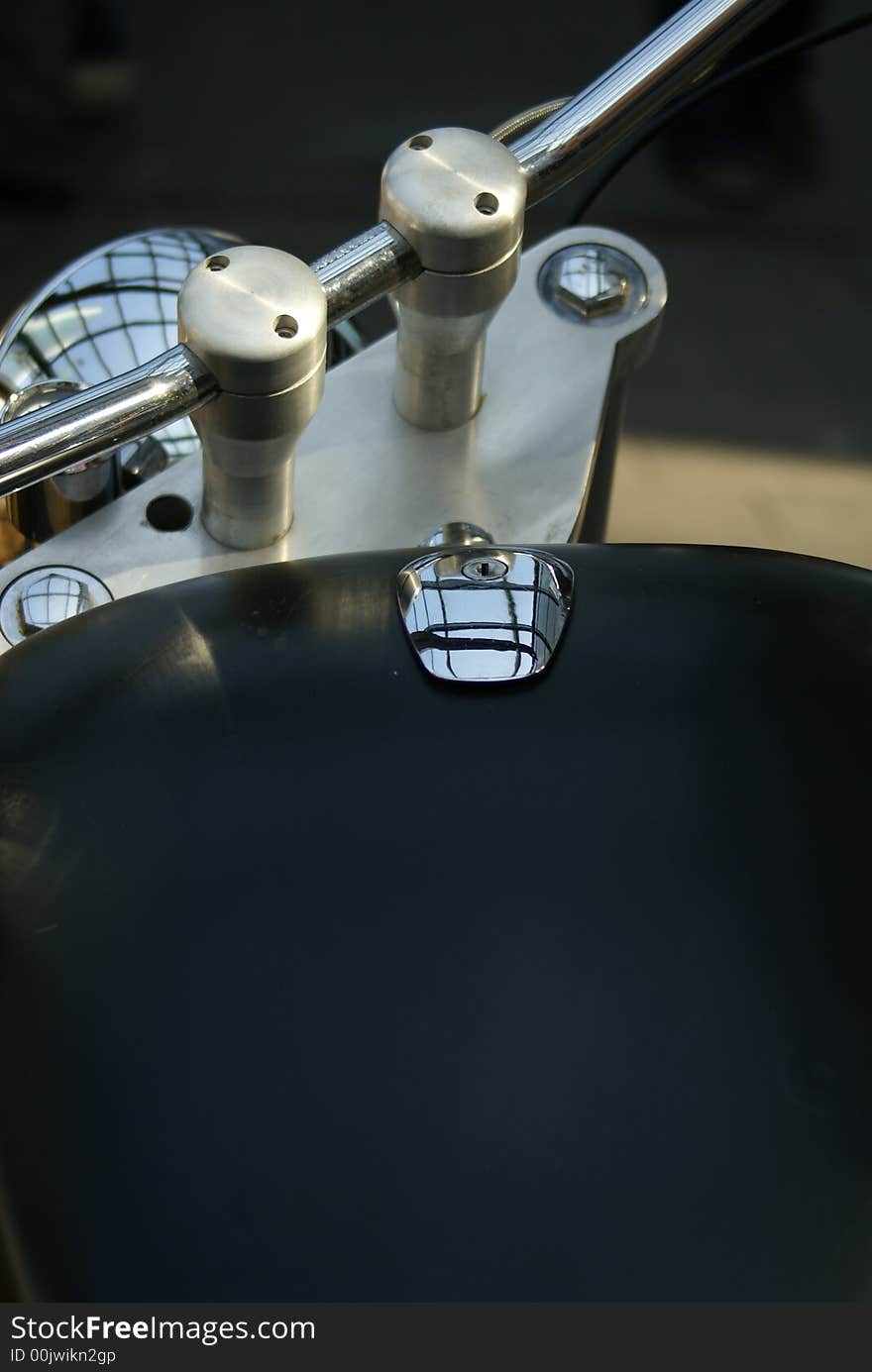 A close-up of a motorcycle gastank with piece of the handlebar and headlight. A close-up of a motorcycle gastank with piece of the handlebar and headlight.