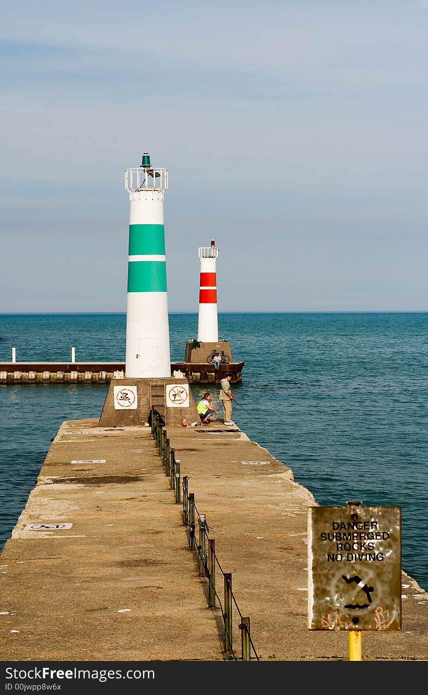 Vertical image of green and red lighthouses at end of piers on lake. Vertical image of green and red lighthouses at end of piers on lake