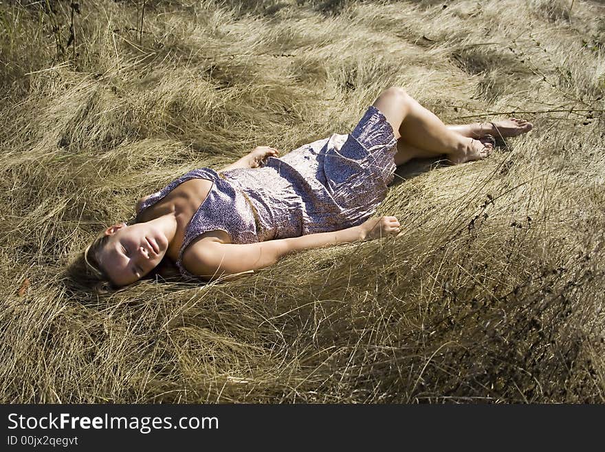 The girl lying on a grass in a hot sunny day. The girl lying on a grass in a hot sunny day