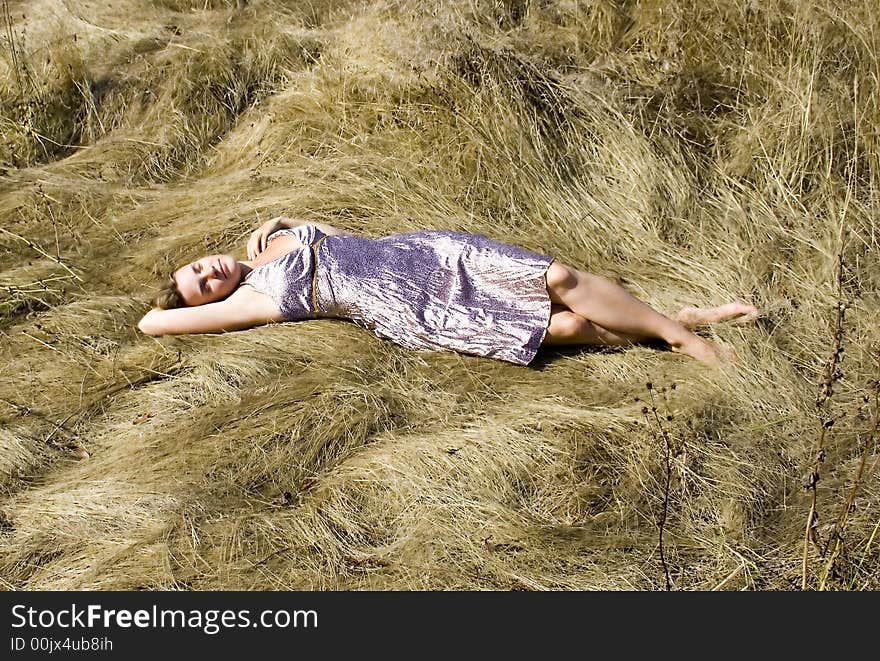 The girl lying on a grass in a hot sunny day. The girl lying on a grass in a hot sunny day