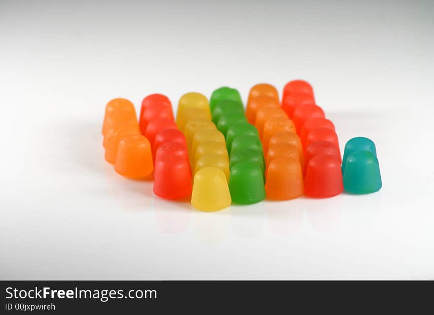 Colorful gummy candy in a line on white