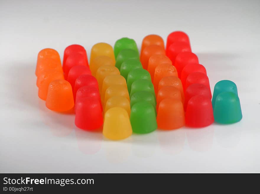 Colorful gummy candy in a line on white