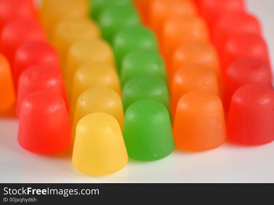 Colorful gummy candy in a line on white