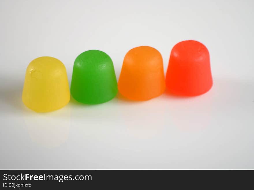 Colorful gummy candy in a line on white