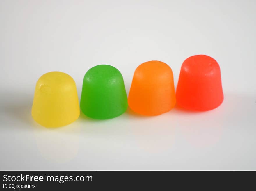 Colorful gummy candy in a line on white