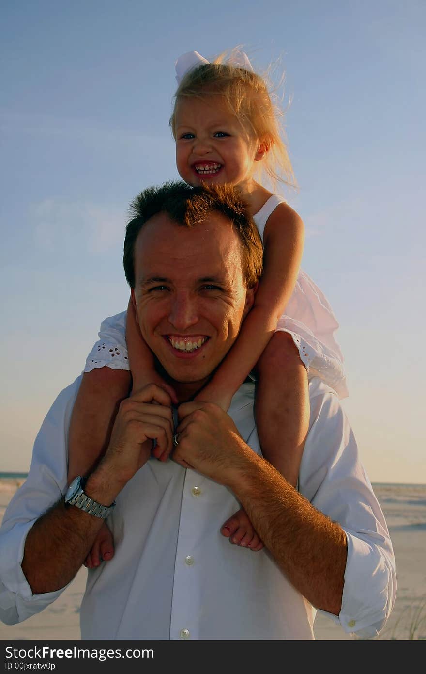 Father holding his daughter on his shoulders at the beach. Father holding his daughter on his shoulders at the beach