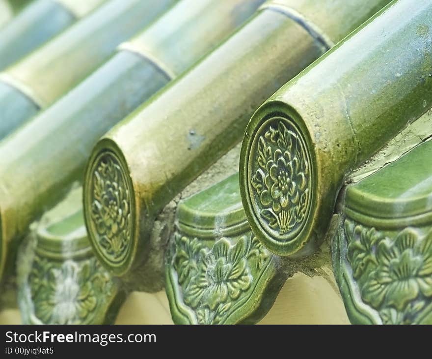 Green, glazed, Chinese roof tiles. Shallow depth of field with the first tile in focus.