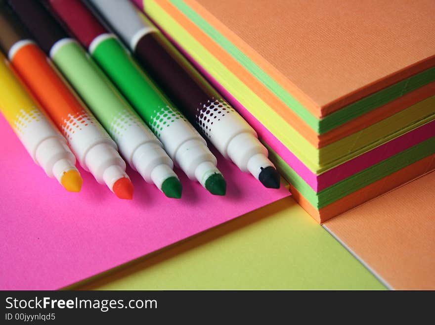 Colorful pencils over colored peaces of paper. Colorful pencils over colored peaces of paper