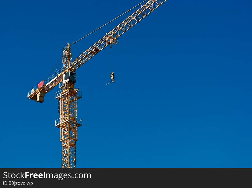 A heavy construction crane against a clear blue sky