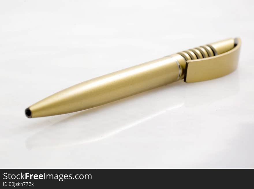 Golden plastic pen on white background.