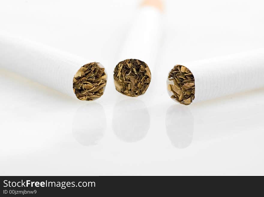 Three cigarets on white background.