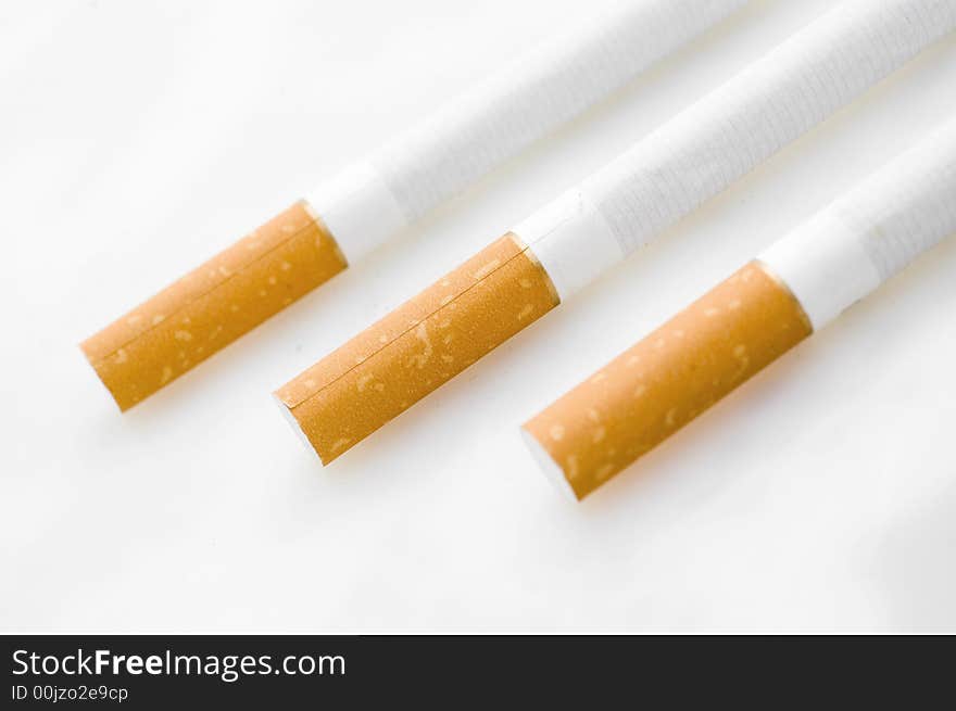 Three cigarets in line on white background.