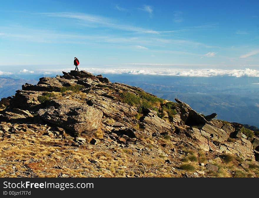 A man admiring a view from a peak in the Pyrenees. A man admiring a view from a peak in the Pyrenees