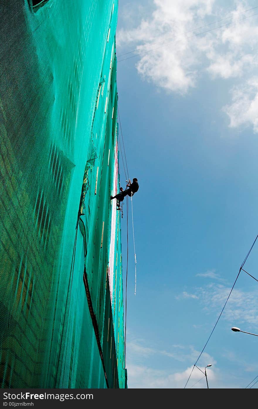 Two workers take a climb on the building wall. Two workers take a climb on the building wall