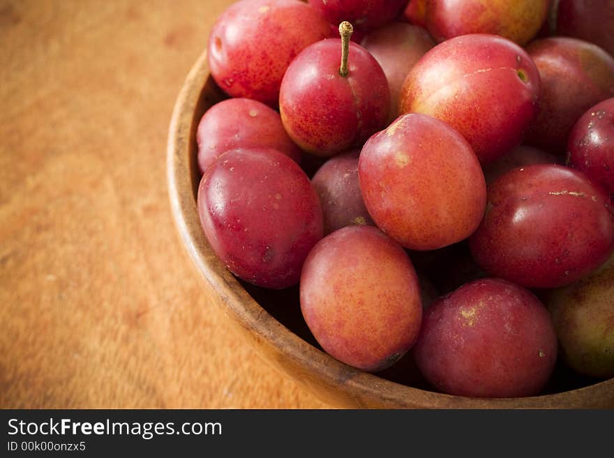 Fresh plums in a wooden bowl