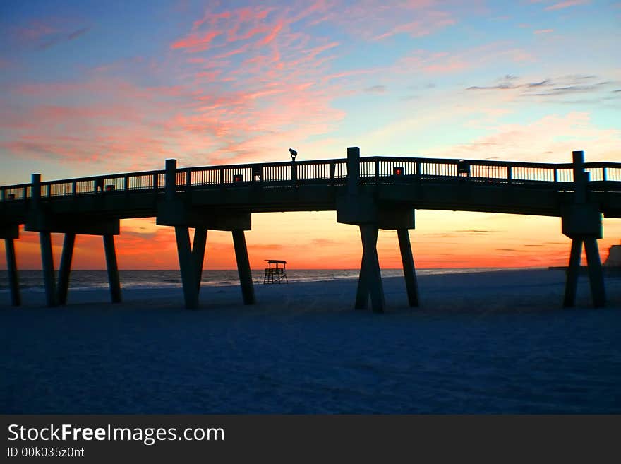 Sunset at the beach with pier and life guard stand. Sunset at the beach with pier and life guard stand