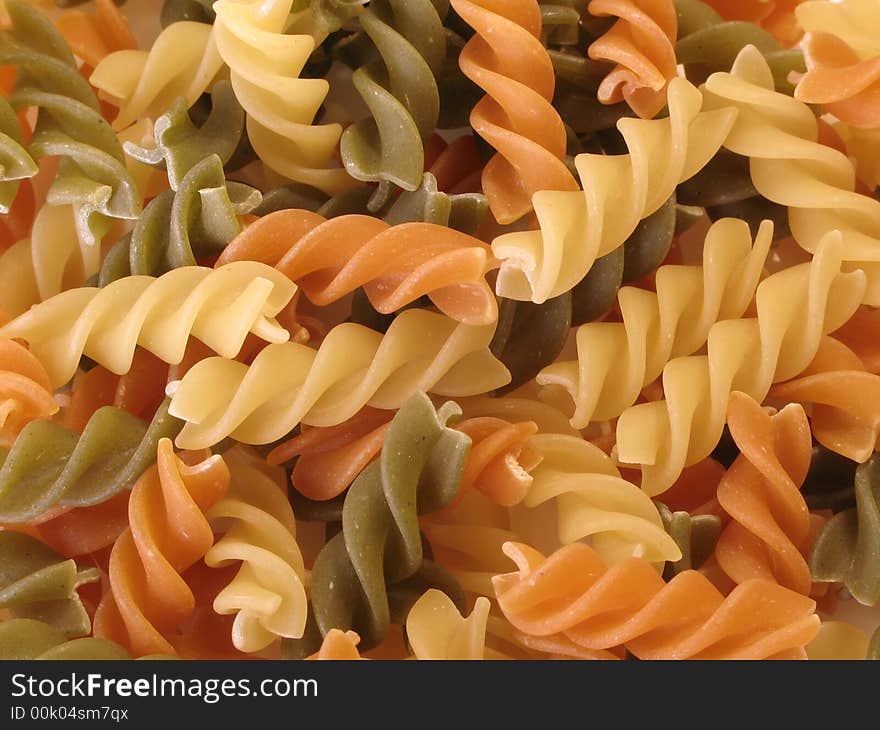 Orange, green and yellow pasta for a background. Orange, green and yellow pasta for a background