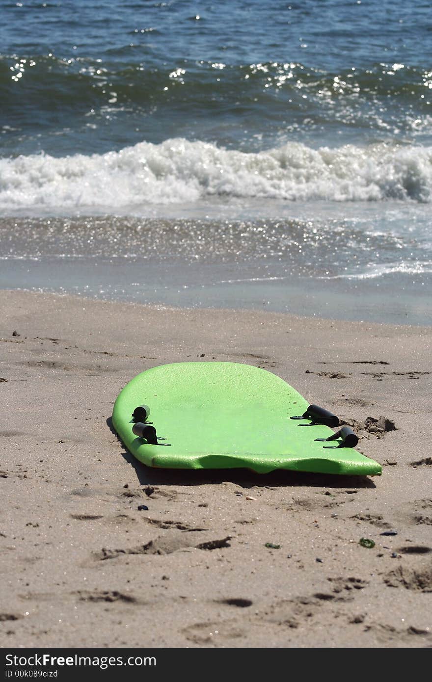 A Boogie board on the beach near the water