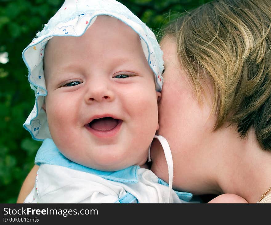 Mother kissing laughing baby