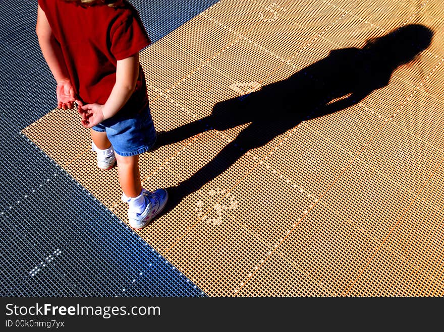 Little girl in red shirt playing hopscotch