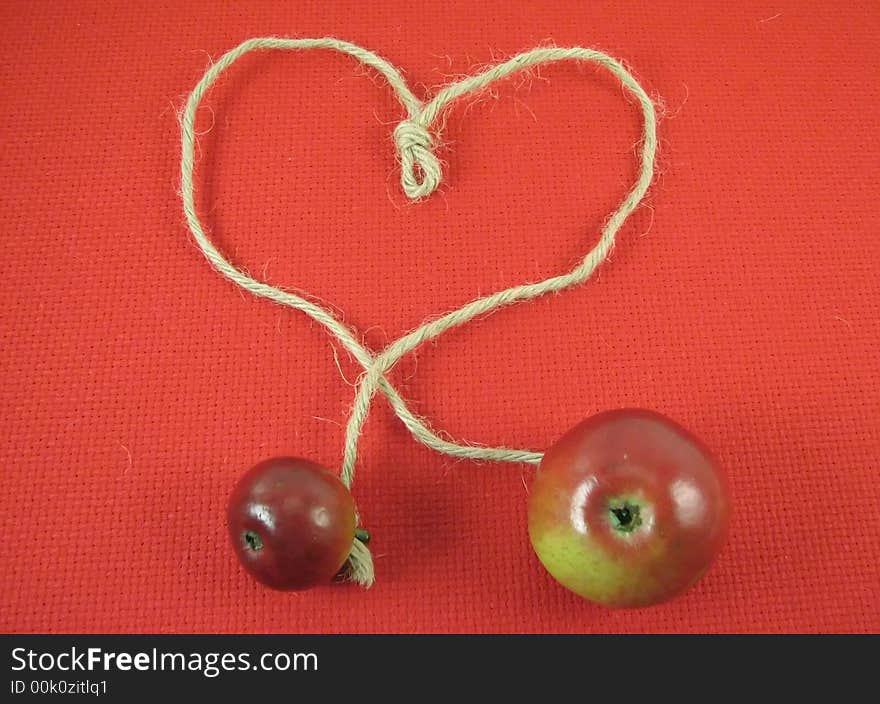 Composite: red apple and string in form of heart