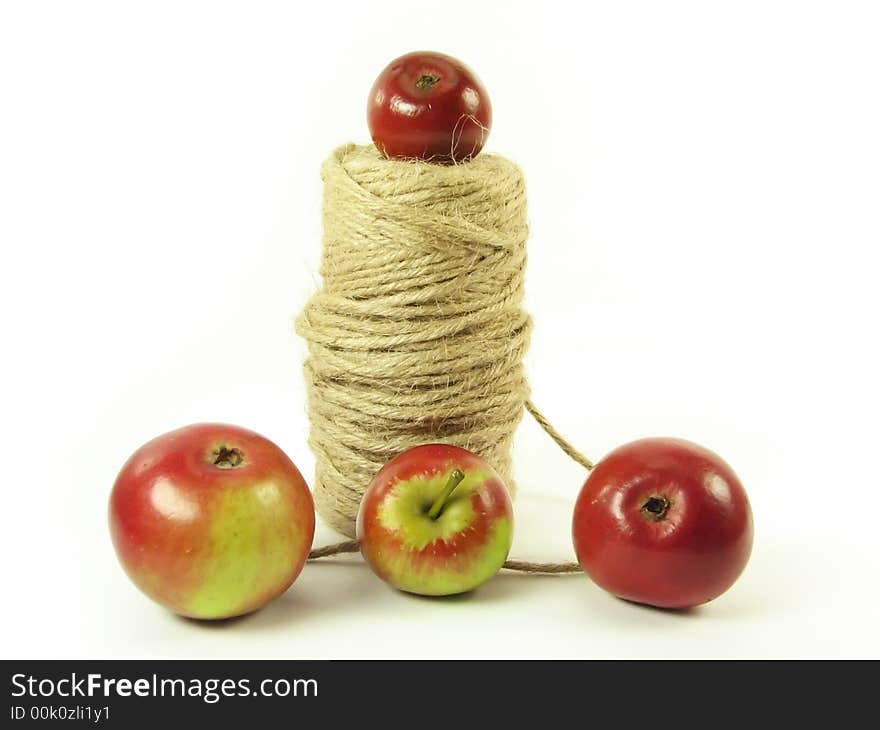 Composite: red apples and string on white background