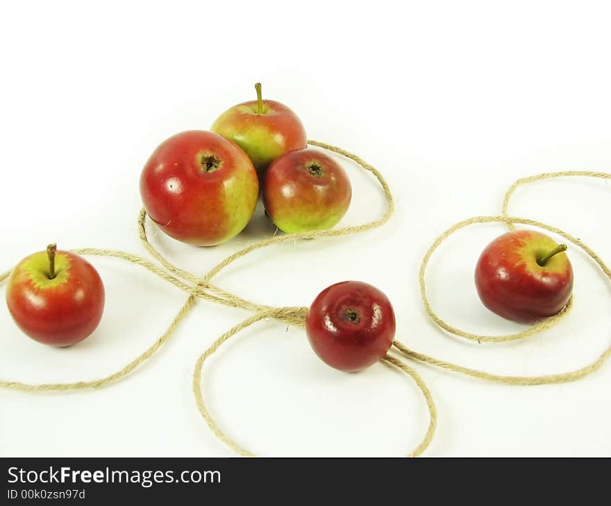 Composite: red apples and string on white background