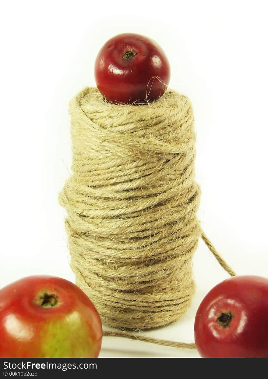 Composite: red apples and string on white background