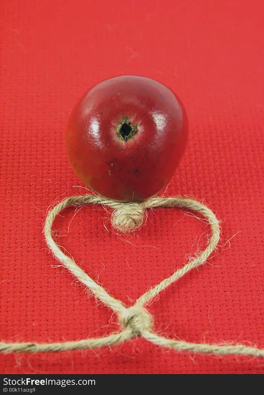 Red apple and string in form o