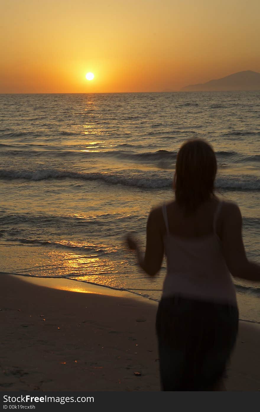 Girl walking on the beach at sunset. Girl walking on the beach at sunset