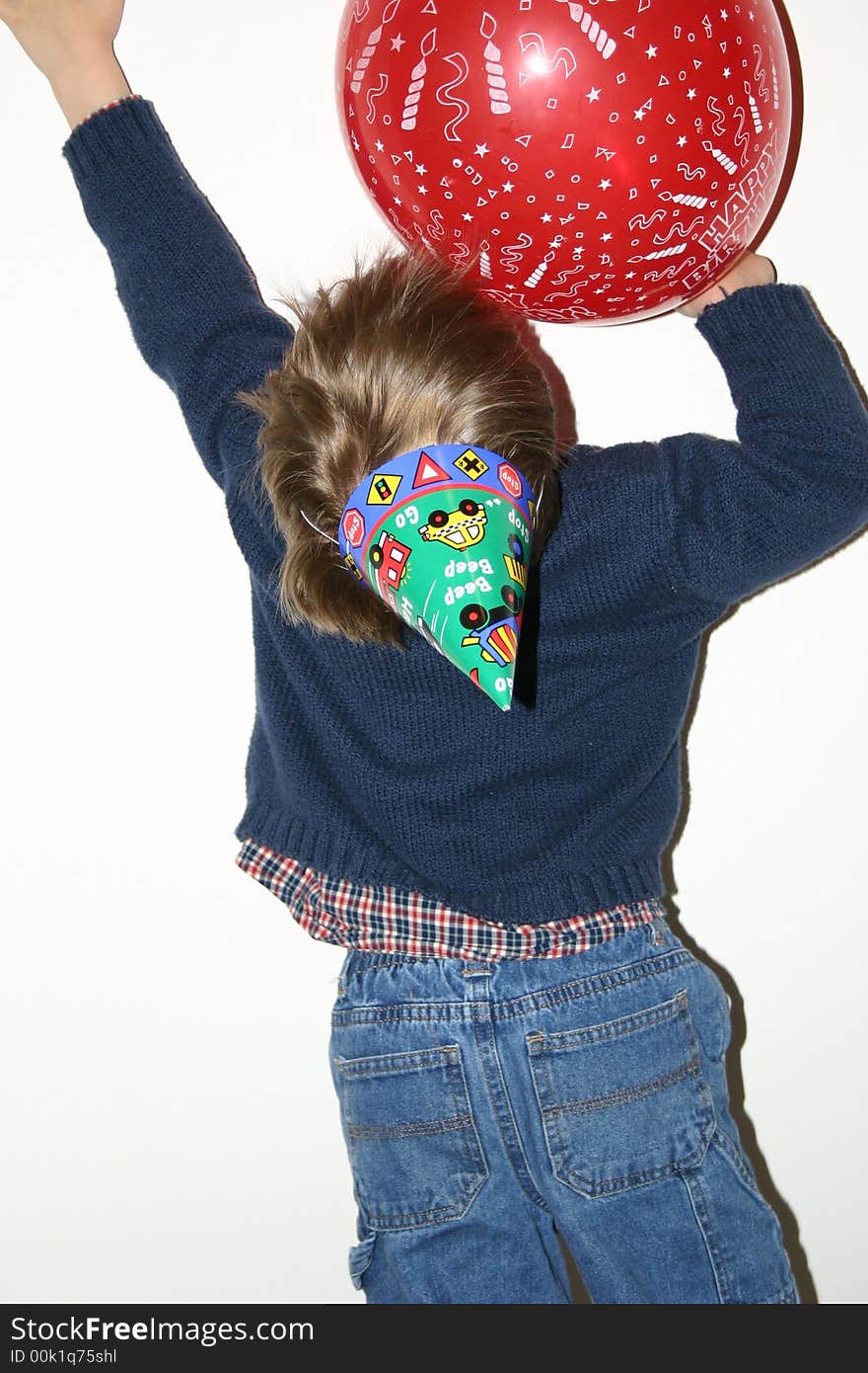 Birthday boy reaching up for balloon