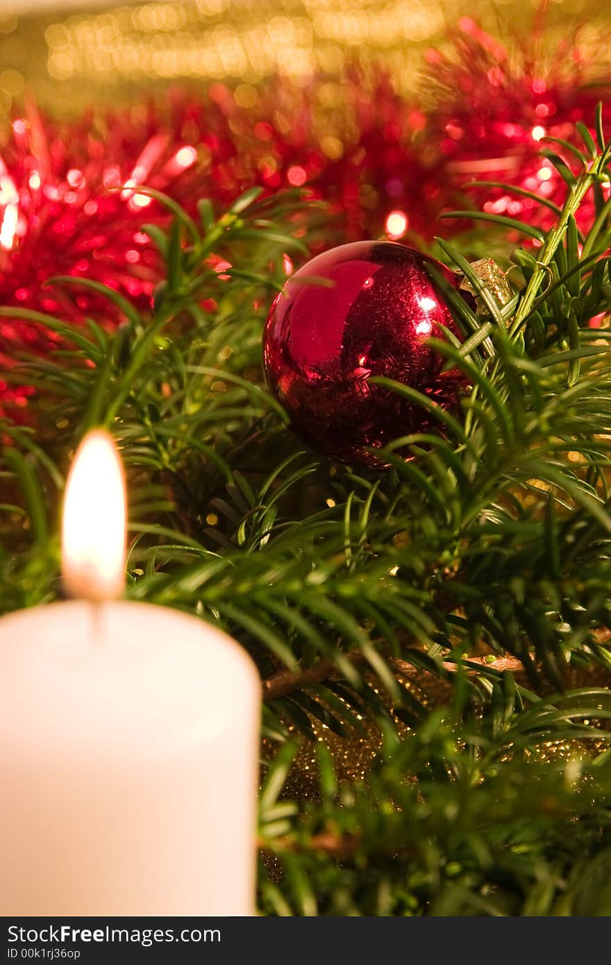 Candle in christmas setting,focus is on the bauble. Candle in christmas setting,focus is on the bauble