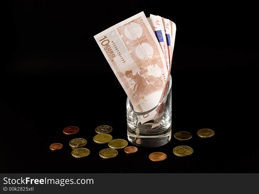 Euros in the glass isolated over black background