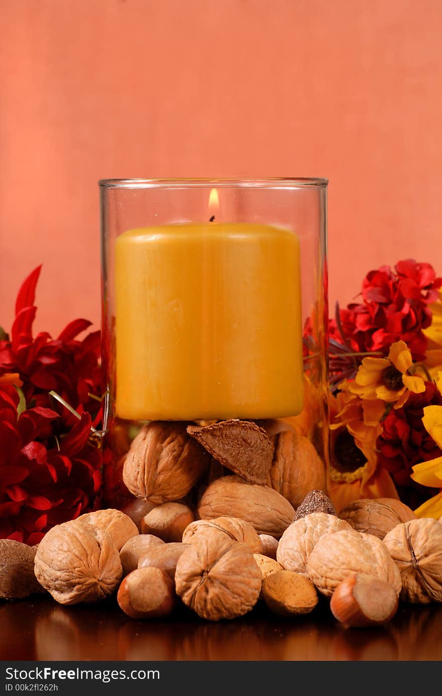 A single candle with nuts in autumn setting. A single candle with nuts in autumn setting