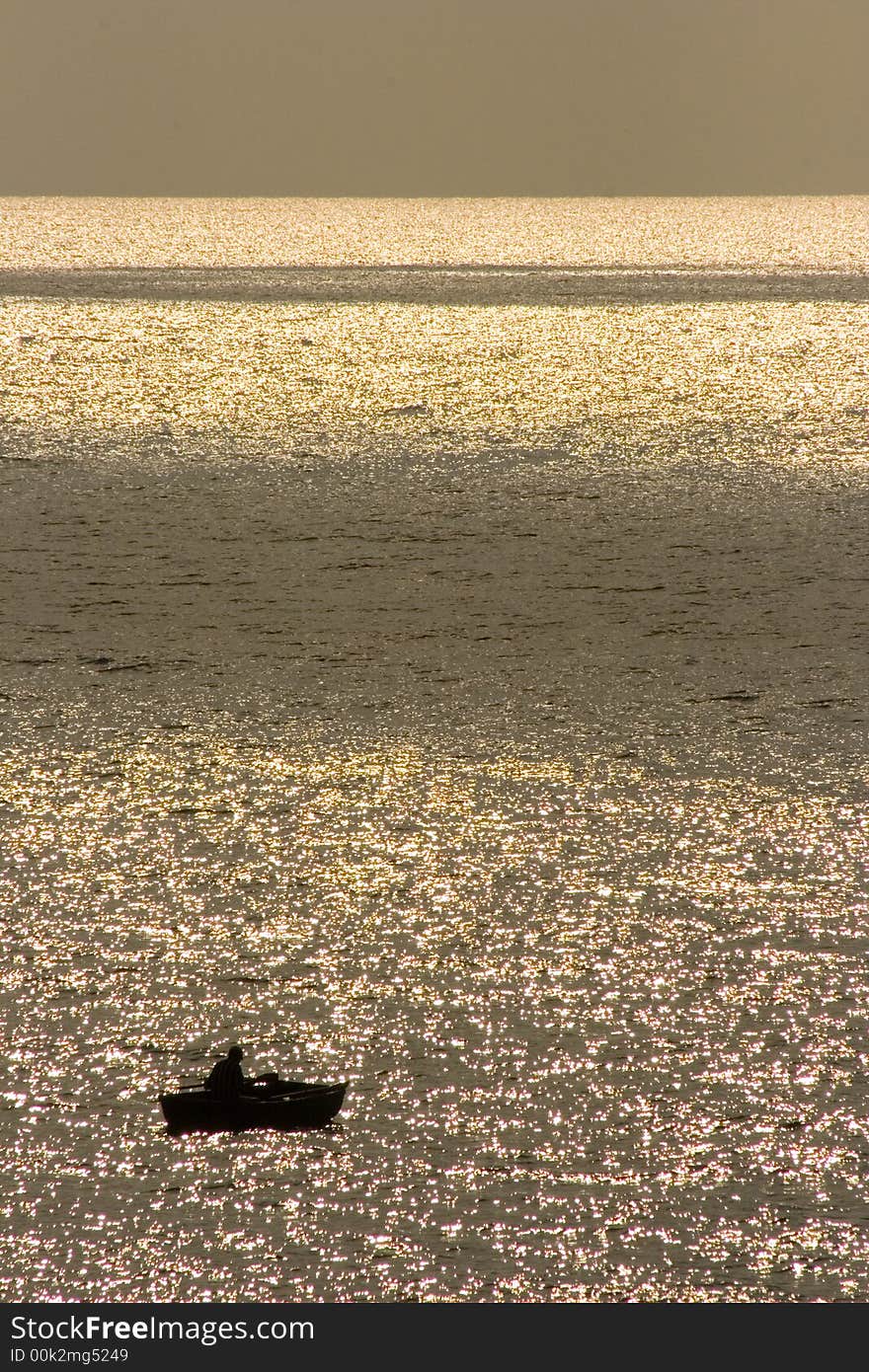 Alone fisherman in the boat, a lot of glare. Alone fisherman in the boat, a lot of glare