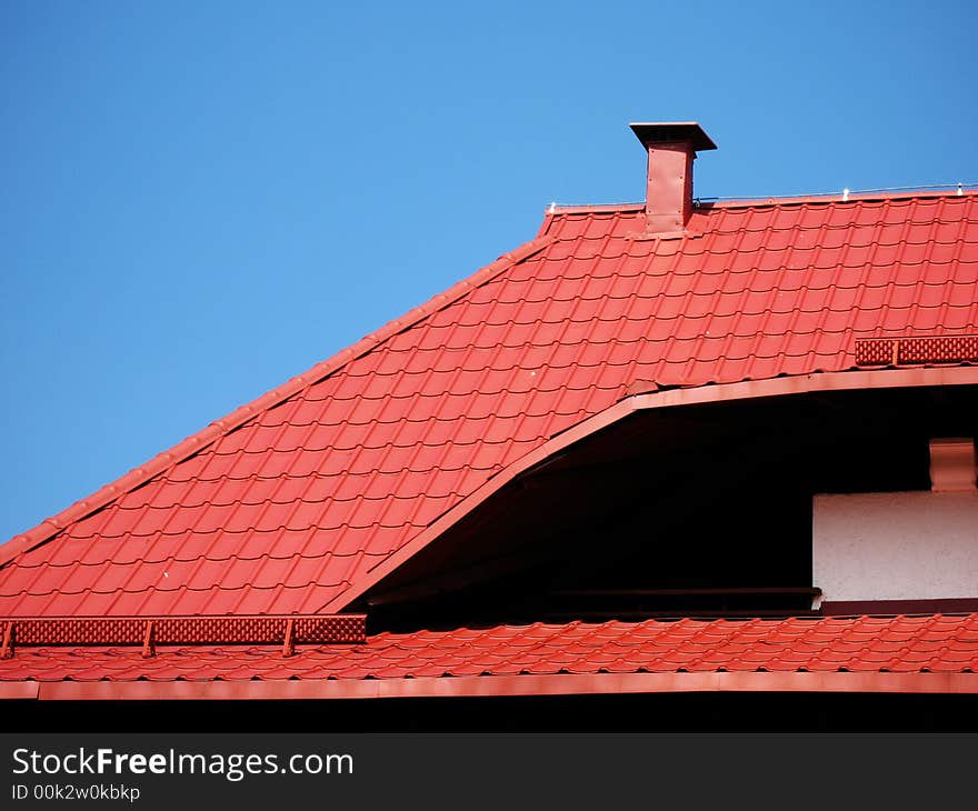 Red roof with a chimney under a blue sky