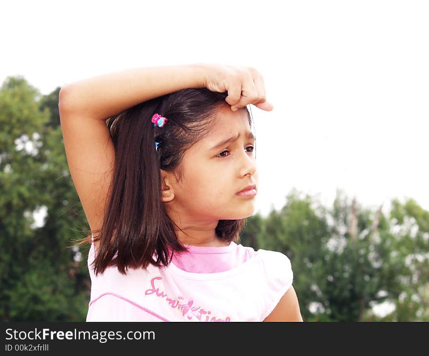 A portrait of a young girl posing with her hand on her head.