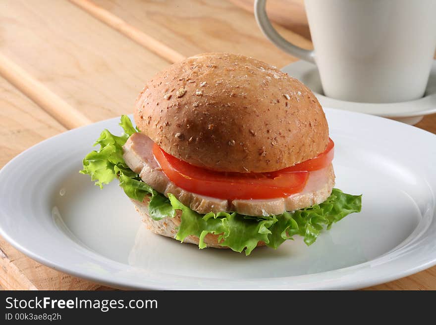 Hamburger on white plate and a cup of tea. Hamburger on white plate and a cup of tea