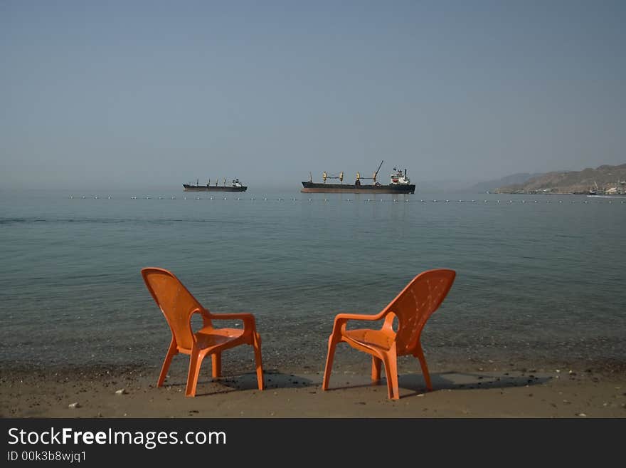 Two boats and two seats on the beach