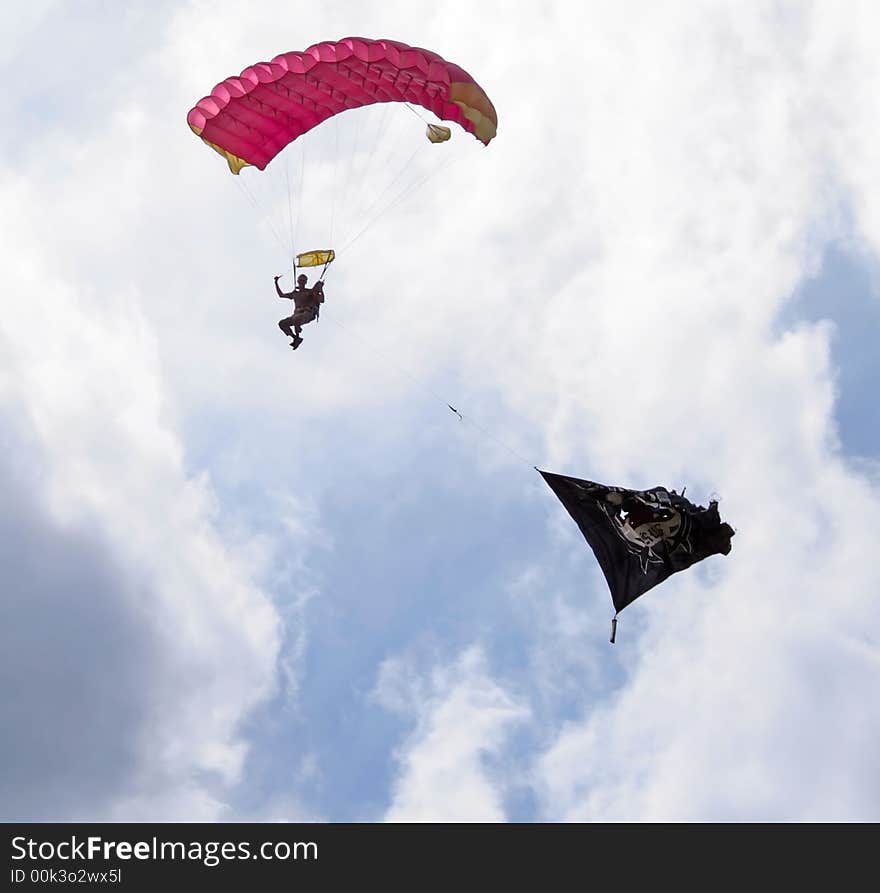 Parachutist with flag against a background of a blue sky