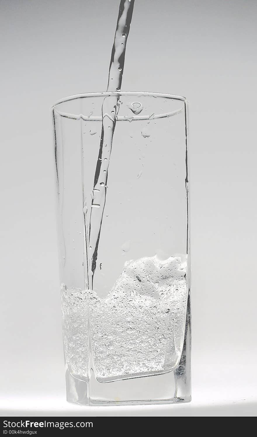 Jet of transparent water flowing in a glass and doing there water mixed with small bubbles. Jet of transparent water flowing in a glass and doing there water mixed with small bubbles