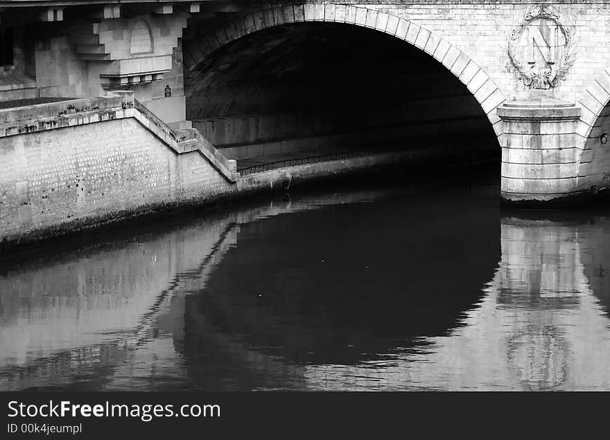 A view of a  bridge in paris and the river pathway