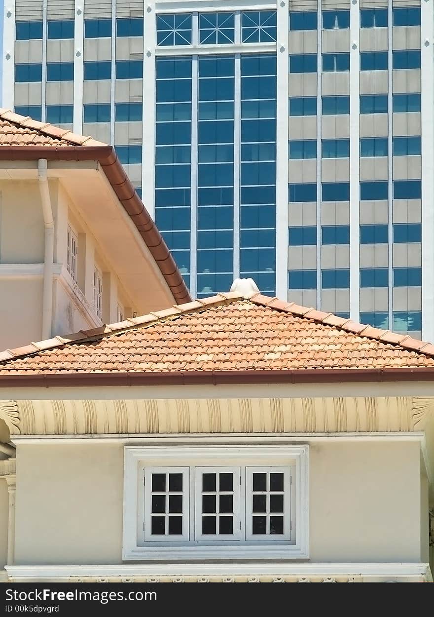 Detail of traditional style building in the foreground with modern, high-rise office building in the background. Detail of traditional style building in the foreground with modern, high-rise office building in the background