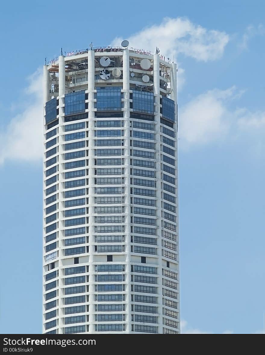 High-rise, circular office building with parabolic antennas at the top floors. Georgetown, penang, malaysia. High-rise, circular office building with parabolic antennas at the top floors. Georgetown, penang, malaysia.