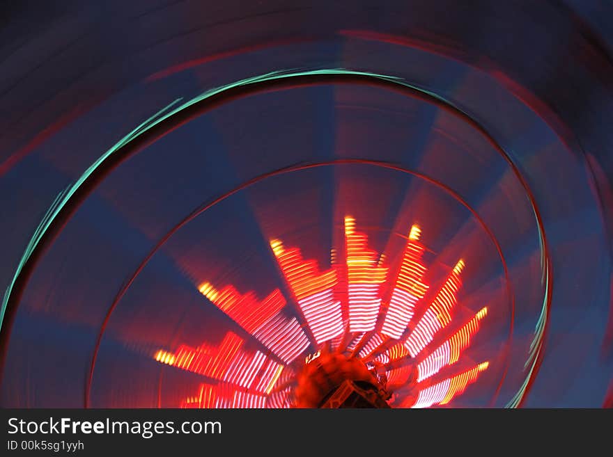 Colorful ferris wheel spinning at night at the amusement park