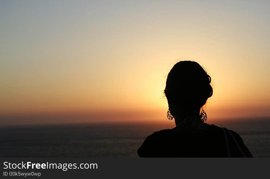 Girl in silhouette enjoying the sunset. Girl in silhouette enjoying the sunset