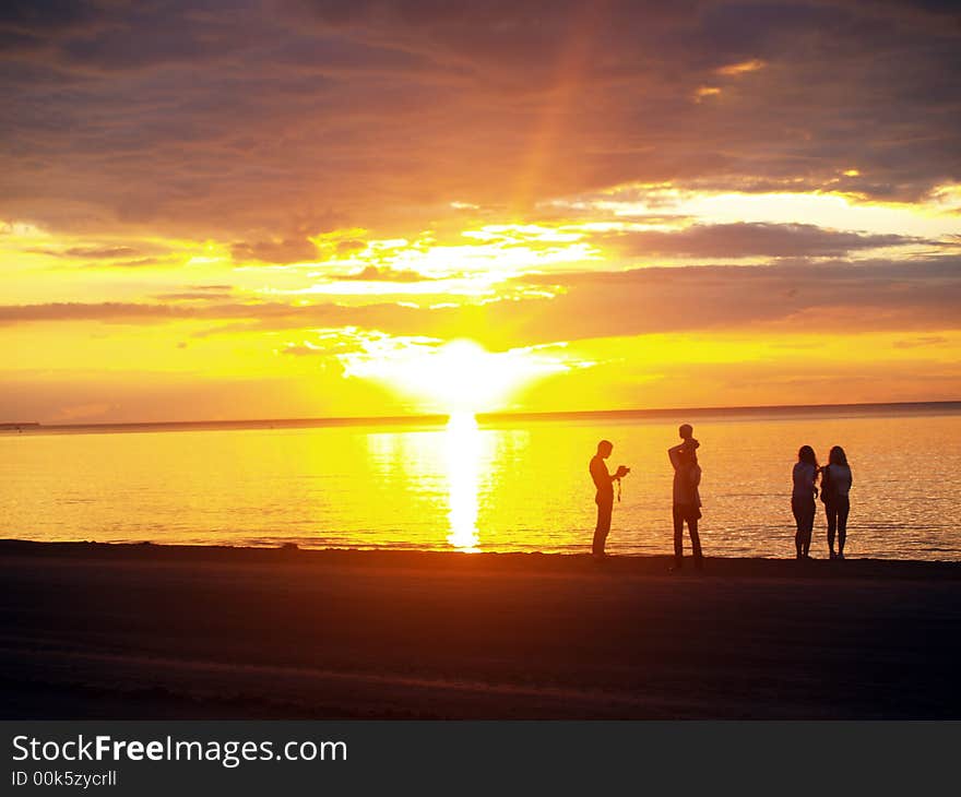 Family looking sunset in the sea