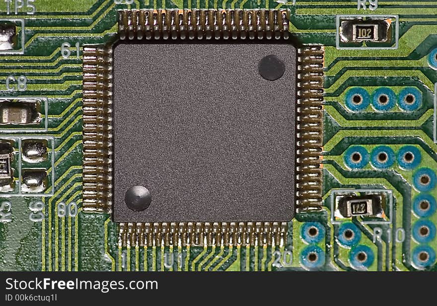 A microchip on green board with a lot of connections. A microchip on green board with a lot of connections